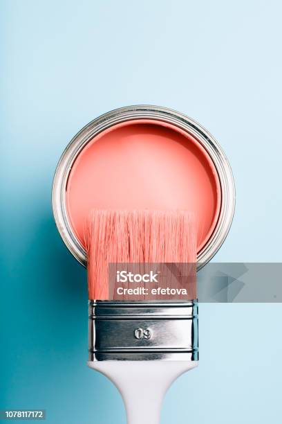 Brush On Open Can Of Living Coral Paint On Blue Pastel Background Stock Photo - Download Image Now