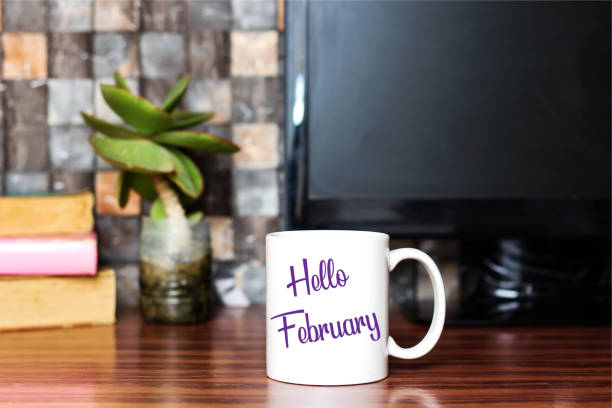 hallo februar geschrieben am weißen kaffeetasse konzept - calendar february desk computer stock-fotos und bilder