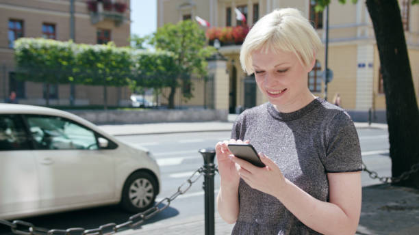 istock Young Blonde Lady Using a Phone in Town 1078129228