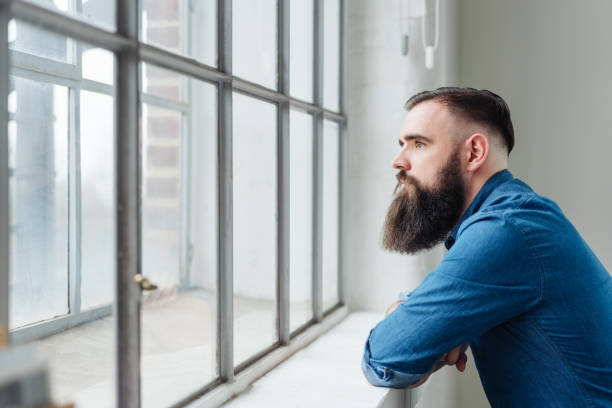 istock Thoughtful bearded man staring out of a window 1078129696