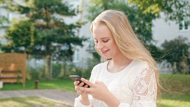 istock Young Blonde Lady Walking and Using a Phone in Town 1078130502