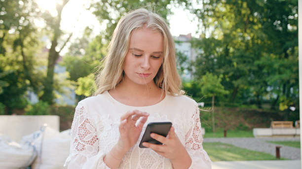 istock Young Blonde Lady Using a Phone in Town 1078131316