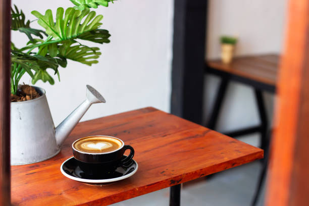 A cup of coffee in a yellow mug. A cup of tea on the table of infront of the tea house at local market in Aceh, Indonesia