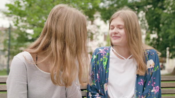 istock Young Ladies Talking on a Bench in Town 1078134128