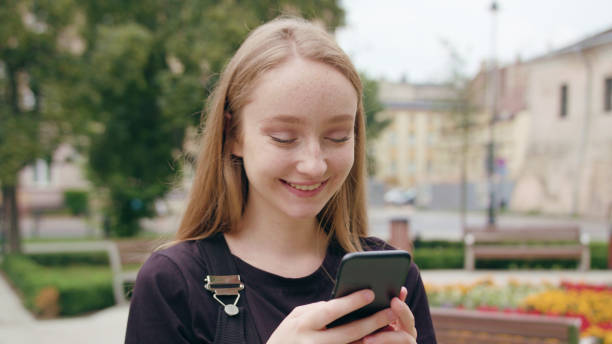 istock Young Redhead Lady Using a Phone in Town 1078138288