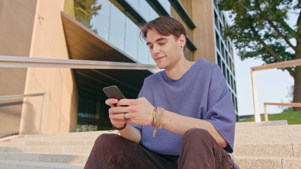 istock Young Man Sitting and Using a Phone in Town 1078143266