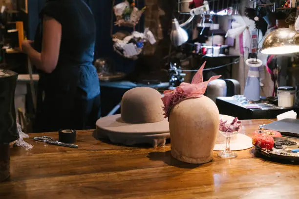Milliner making handmade customized hats in her workshop.