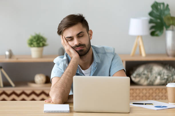 istock Exhausted man fall asleep near laptop at home workplace 1078149270