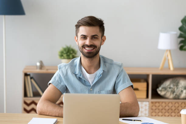 istock Portrait of happy male worker sitting at table using laptop 1078149298
