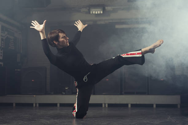 istock modern beautiful dancer in black clothes posing against the Studio in the smoke 1078152680