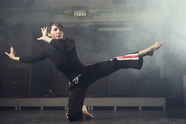 istock modern beautiful dancer in black clothes posing against the Studio in the smoke 1078152682