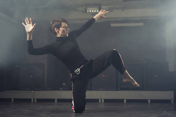istock modern beautiful dancer in black clothes posing against the Studio in the smoke 1078152688