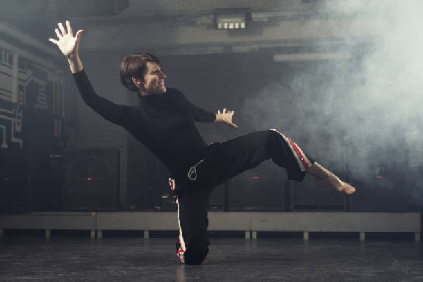 istock modern beautiful dancer in black clothes posing against the Studio in the smoke 1078152690