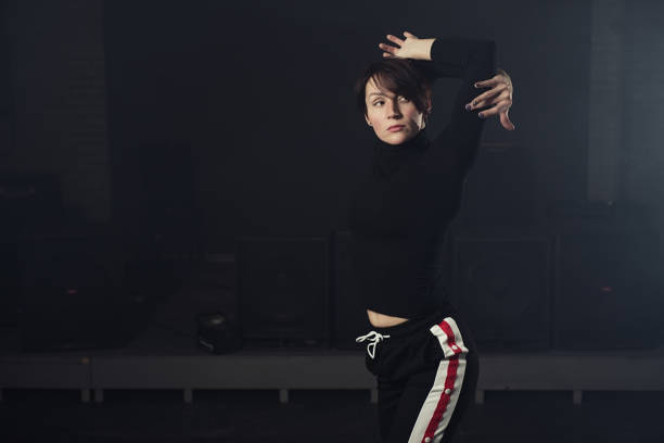 istock modern beautiful dancer in black clothes posing against the Studio in the smoke 1078154100