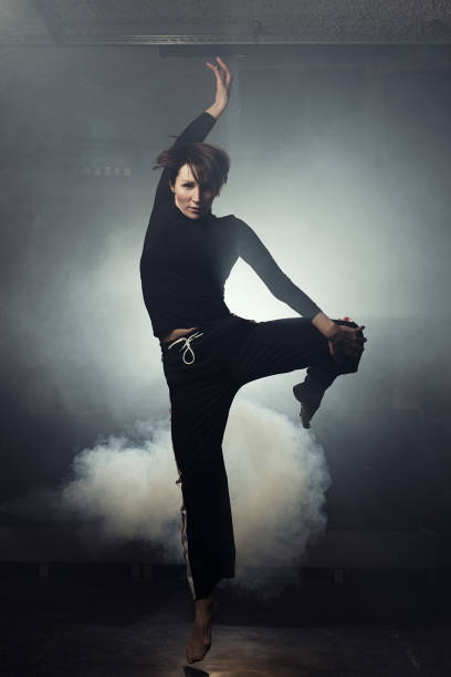 istock modern beautiful dancer in black clothes posing against the Studio in the smoke 1078155846