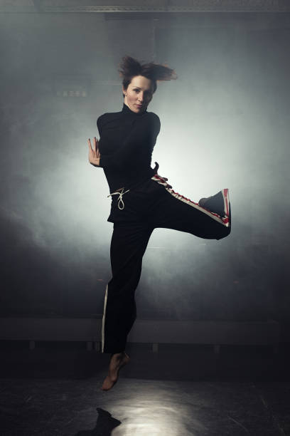 istock modern beautiful dancer in black clothes posing against the Studio in the smoke 1078155848