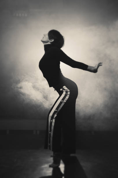 istock modern beautiful dancer in black clothes posing against the Studio in the smoke 1078156002