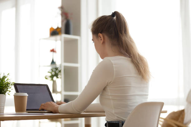 istock Focused girl typing at laptop working from home 1078156184