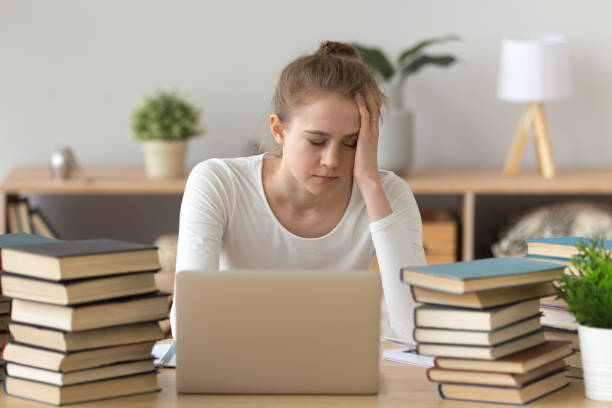 istock Tired girl fall asleep sitting at table with books around 1078156258