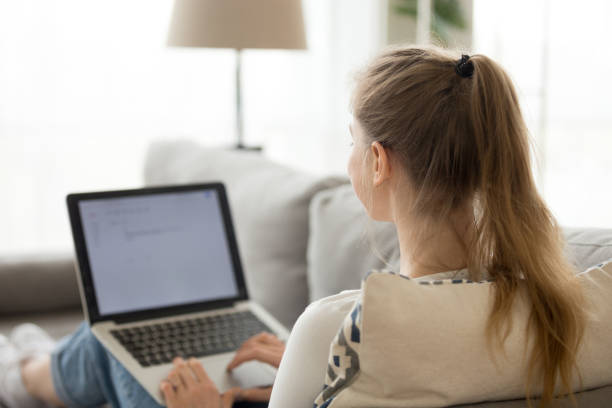 istock Female relax on couch browsing internet on laptop 1078156290