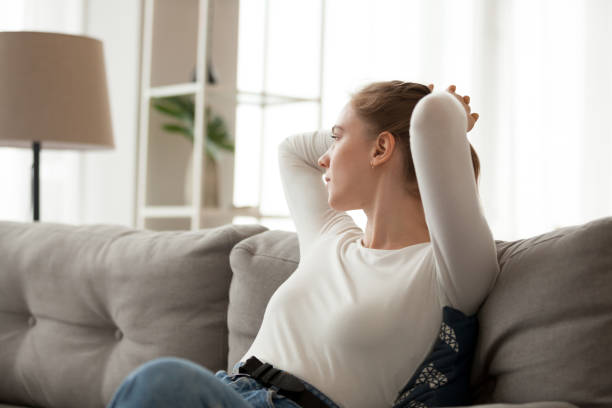 istock Young female relax on couch looking in distance thinking 1078156350