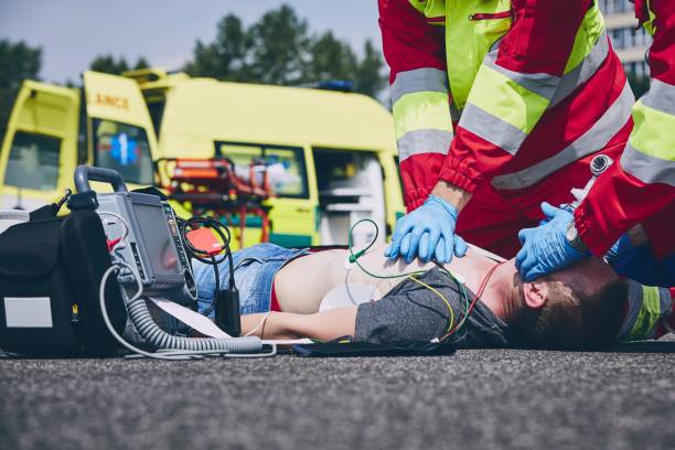 Cardiopulmonary resuscitation on road Cardiopulmonary resuscitation. Rescue team (doctor and a paramedic) resuscitating the man on the road. defibrillator photos stock pictures, royalty-free photos & images