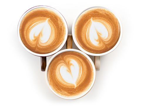 Three cups of coffee cappuccino saucer on white background isolation, top view