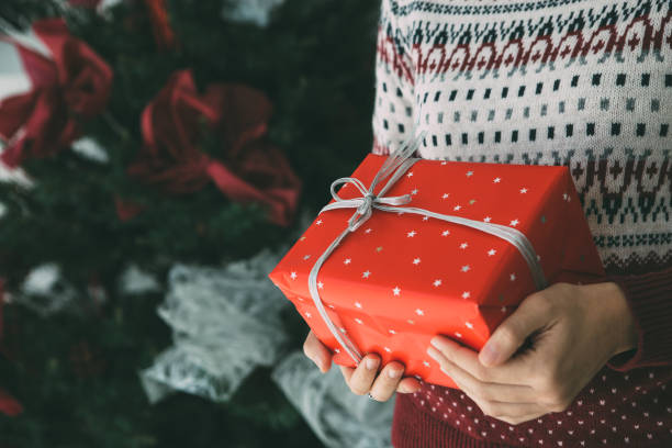 istock Young woman holds Christmas gift 1078172068