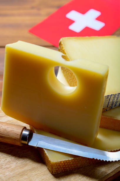 assortment of swiss cheeses emmental or emmentaler medium-hard cheese with round holes, gruyere, appenzeller and raclette used for traditional cheese fondue and gratin and flag of switzerland - cheese emmental cheese switzerland grated imagens e fotografias de stock