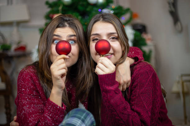 istock Playful girlfriends making noses with baubles 1078201254