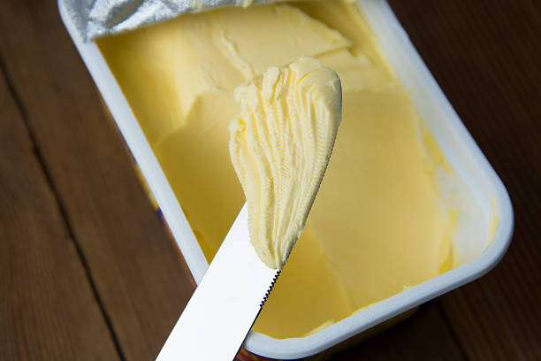 schlagsahne butter in plastikbehälter mit messer, butter zum kochen und sandwiches. rustikaler holztisch. - butter dairy product fat food stock-fotos und bilder