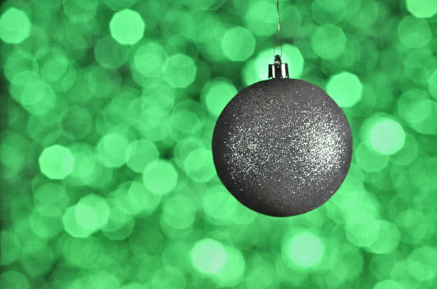 istock Silver New Year and Christmas ball on green background with bokeh 1078201536