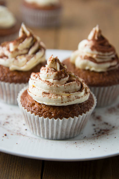 istock Chocolate cupcakes with whipped cream on rustic wooden table. Homemade dessert. 1078201556