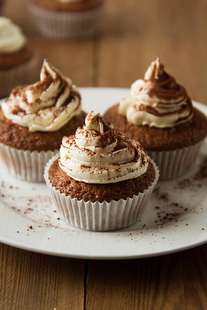istock Chocolate cupcakes with whipped cream on rustic wooden table. Homemade dessert. 1078201620