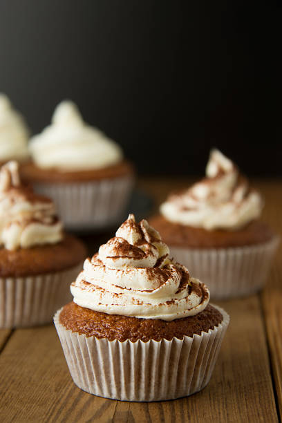 istock Chocolate cupcakes with whipped cream on rustic wooden table. Homemade dessert. 1078201680