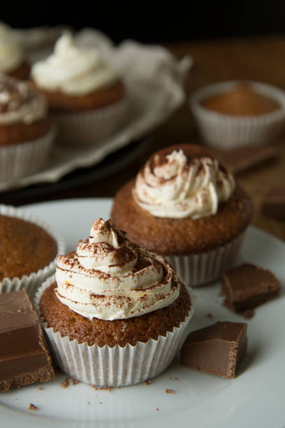 istock Chocolate cupcakes with whipped cream on rustic wooden table. Homemade dessert. 1078201824