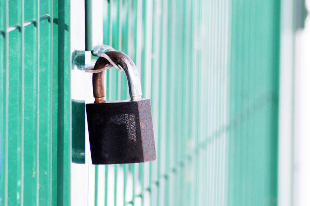 istock A rusty chain on a weathered metal door with a padlock 1078201834