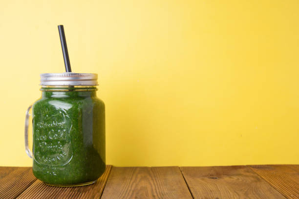 istock Spinach smoothie with green apple. Healthy smoothie. Wooden rustic table with yellow background. 1078202070