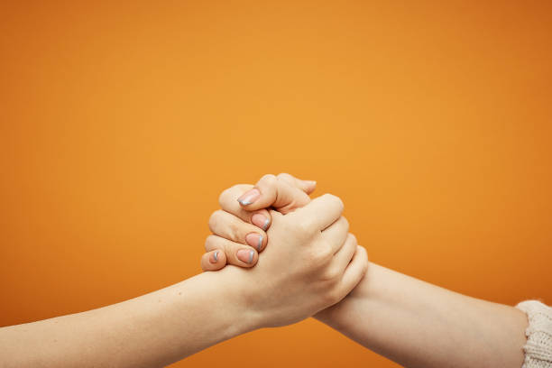 istock understanding and agreement, a handshake on an orange background 1078202336