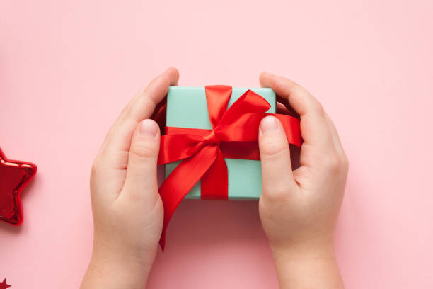 buon natale e felice anno nuovo. sfondo rosa - gift human hand box giving foto e immagini stock