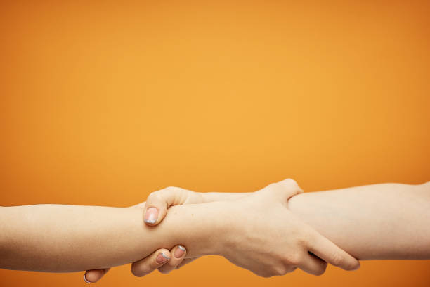 istock understanding and agreement, a handshake on an orange background 1078203454