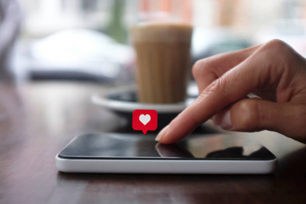 jonge vrouw met behulp van slimme telefoon met sociale media symbolen - volgen activiteit stockfoto's en -beelden