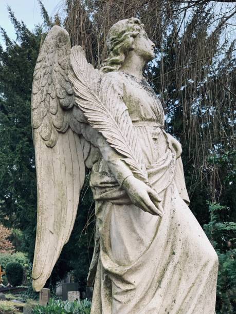 istock Angel holds a palm leaf, old tomb statue 1078205734