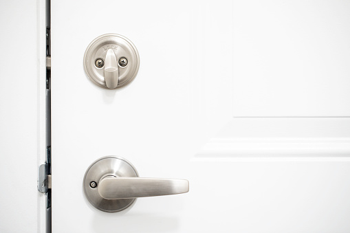 Silver metal deadbolt lock on a white door