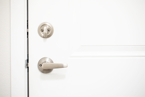 Silver metal deadbolt lock on a white door