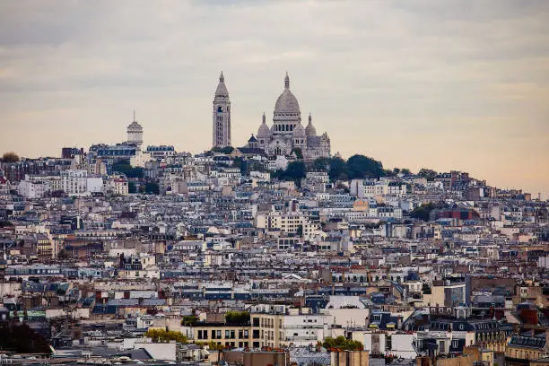 Paris cityscape with Monmartre neighborhood and Sacre Coeur Basilica in the distance.
