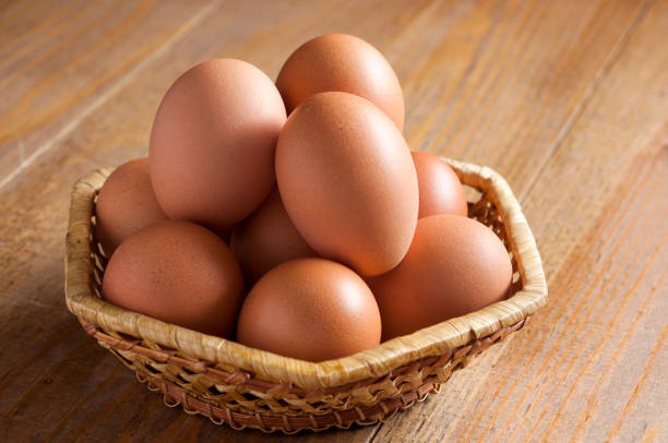istock Brown chicken eggs lies in a wicker basket on a wooden table. 1078214706