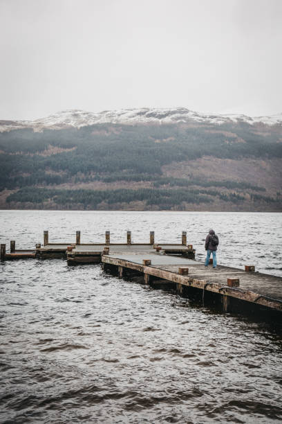 istock Man walking on a pier on Loch Lomond in Scotland. 1078215510