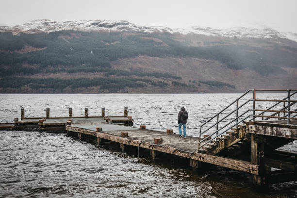 istock Man walking on a pier on Loch Lomond in Scotland. 1078215518