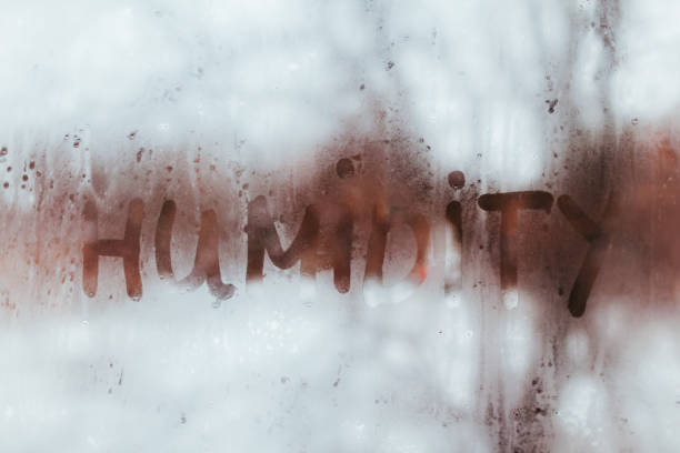 palavra de umidade escrita na janela molhada. alto nível de humidade no apartamento. - humidade - fotografias e filmes do acervo